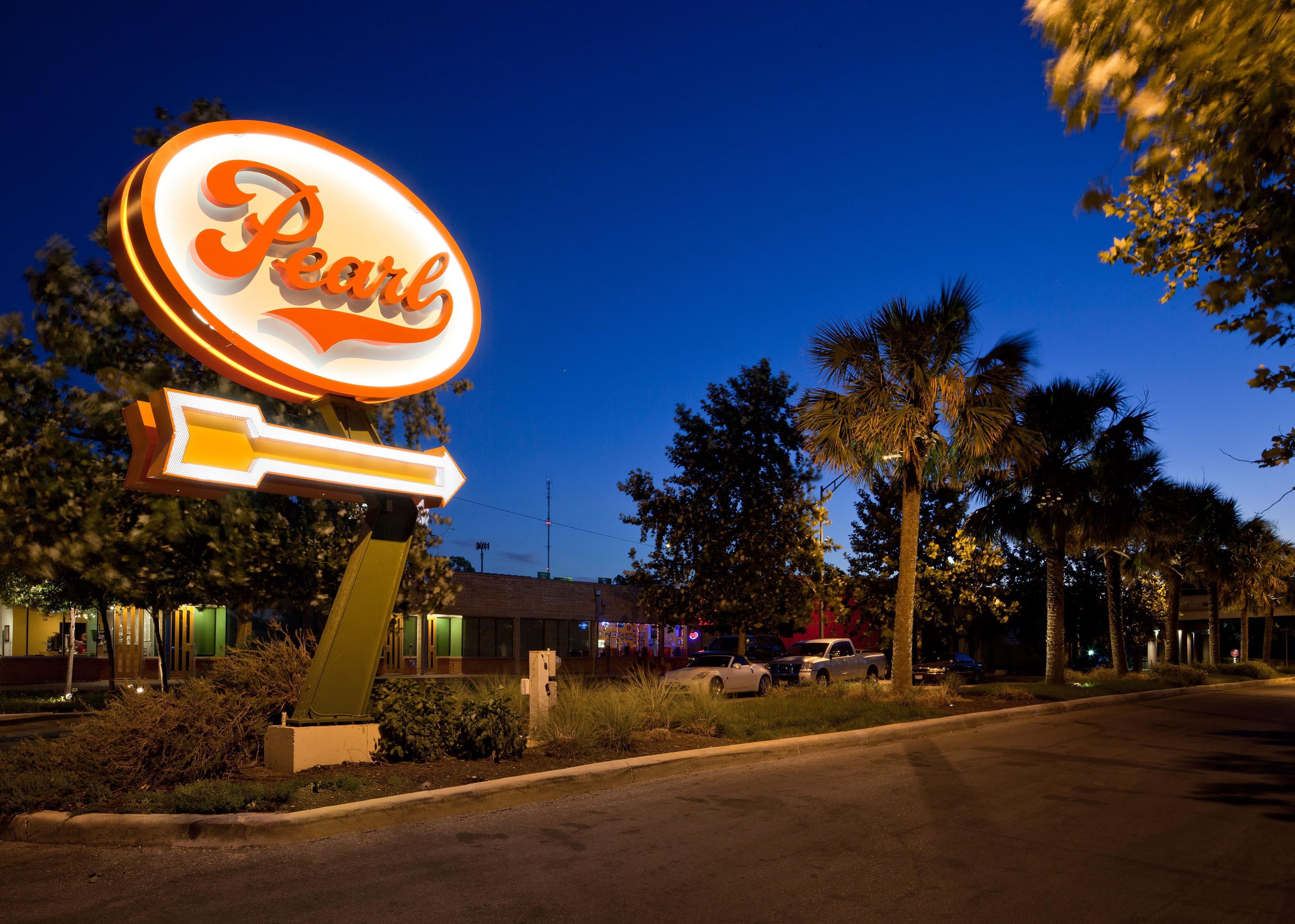 Un letrero de neón con la palabra 'Pearl' por la noche.