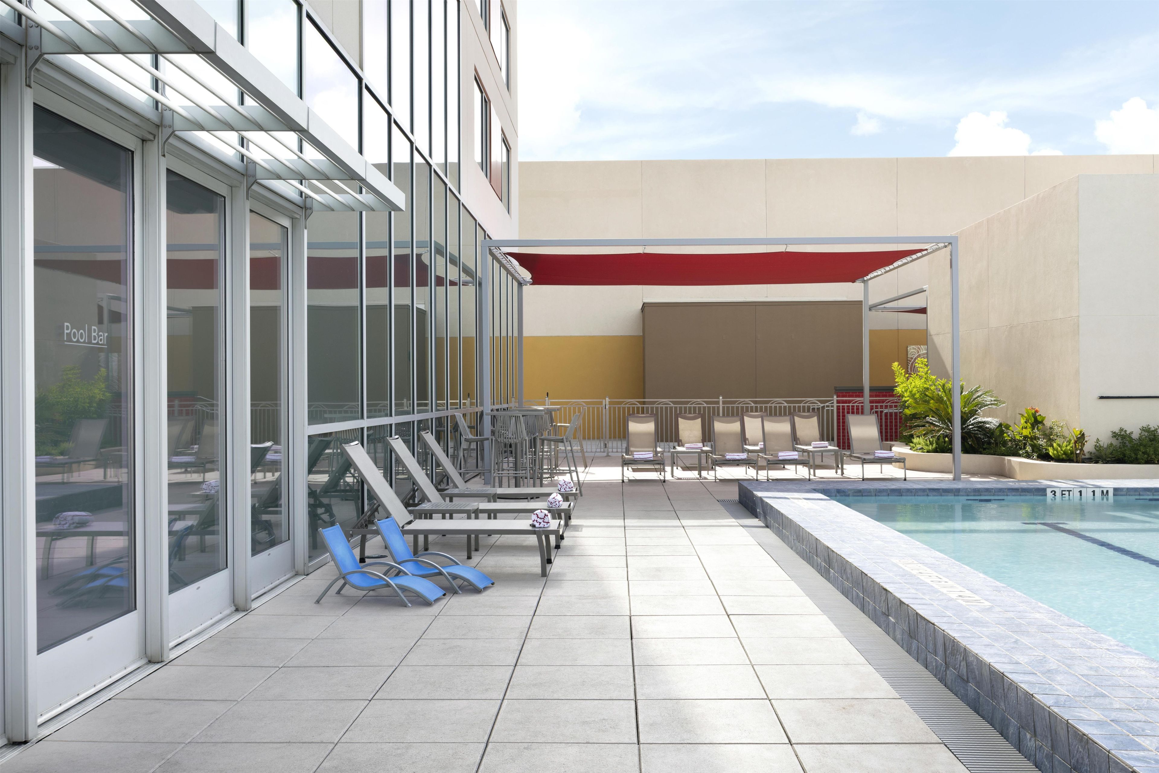 A poolside area with lounge chairs and a pool.