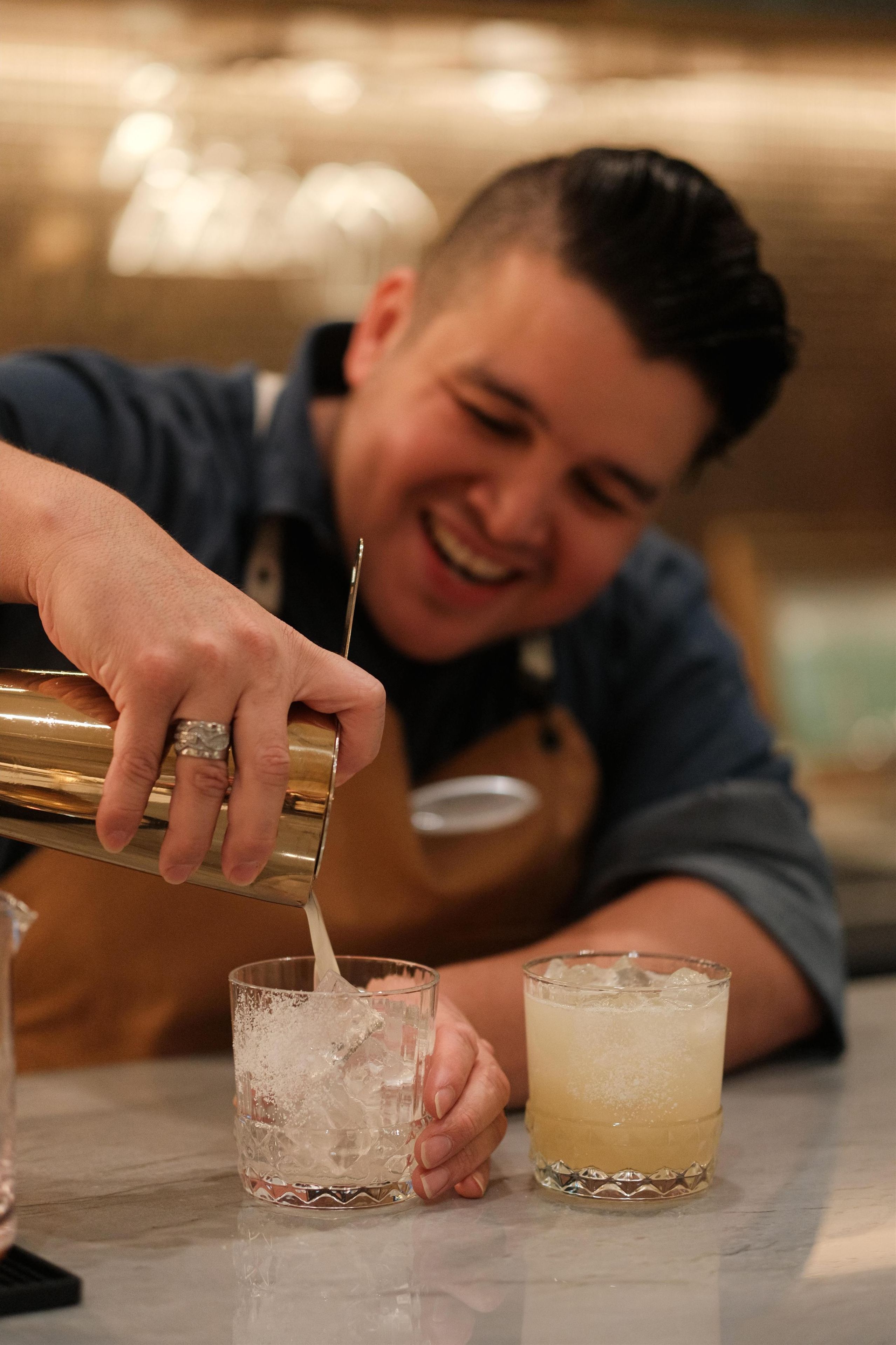 A person pouring a drink into a glass.