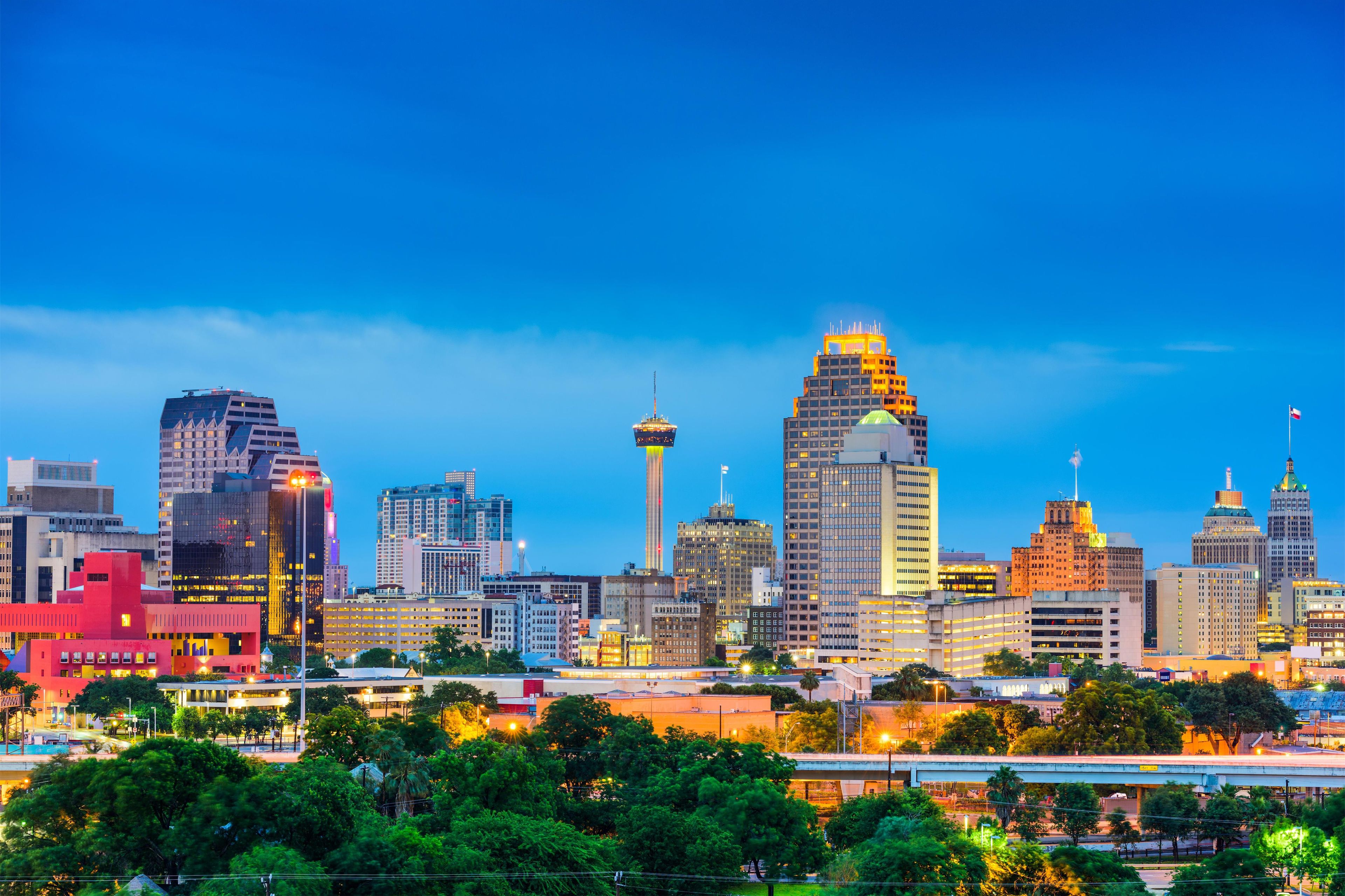 A city skyline with various high-rise buildings, including a distinctive tower with a spire.