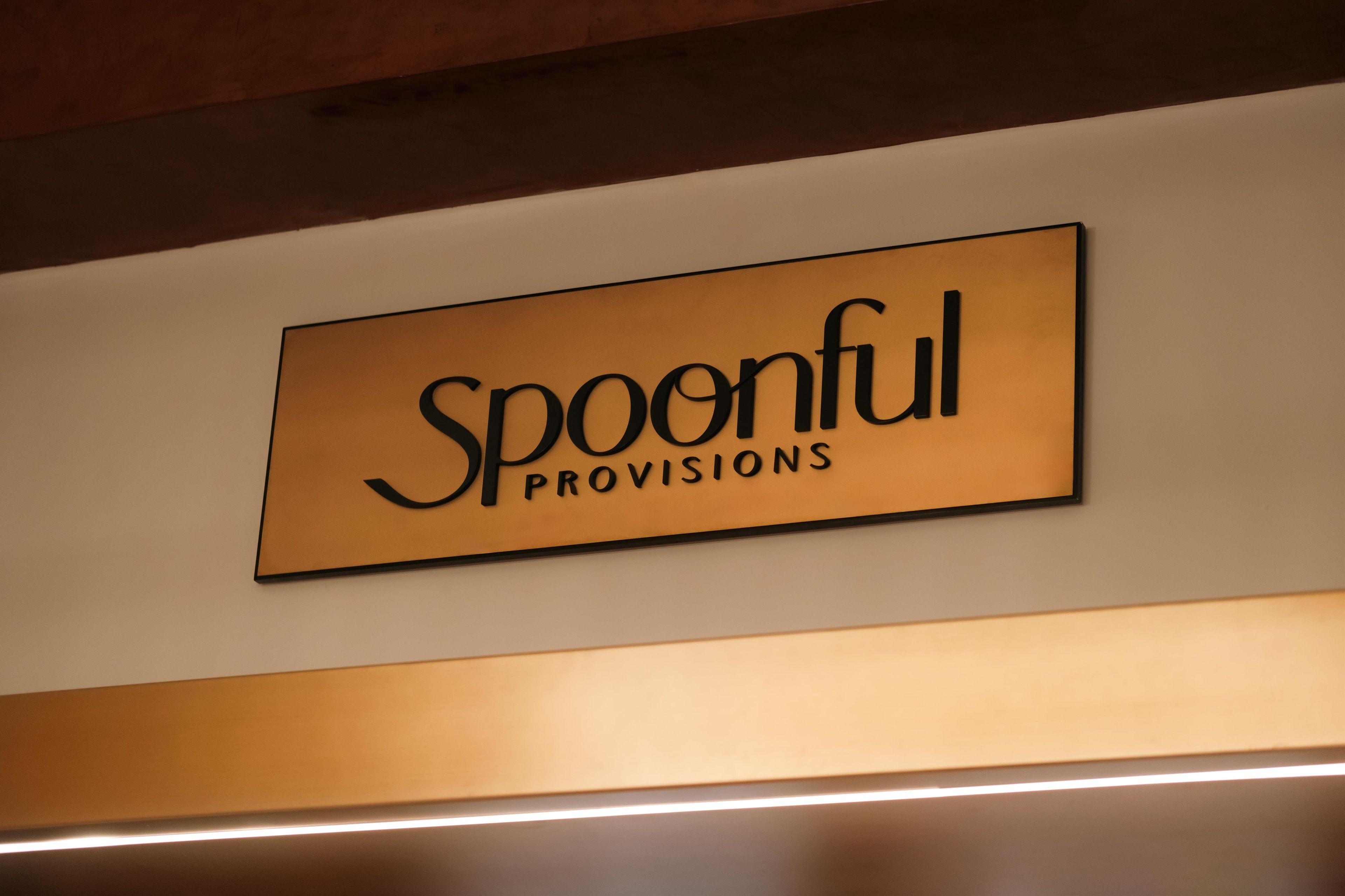 A sign with the text 'Spoonful Provisions' on a wall.