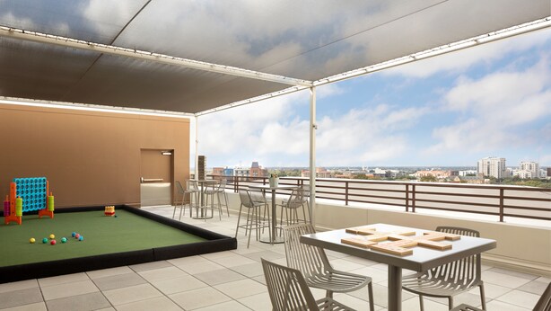 A spacious balcony with a pool table, chairs, and a table set for dining. - Grand Hyatt San Antonio River Walk (San Antonio)