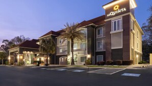 A multi-story hotel with a prominent 'La Quinta' sign, a covered entrance, and a parking lot.