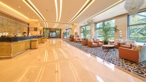 A spacious lobby with a reception desk, seating area, and large windows offering a view of the outdoors. - Parkview Hotel Shanghai (Shanghai)