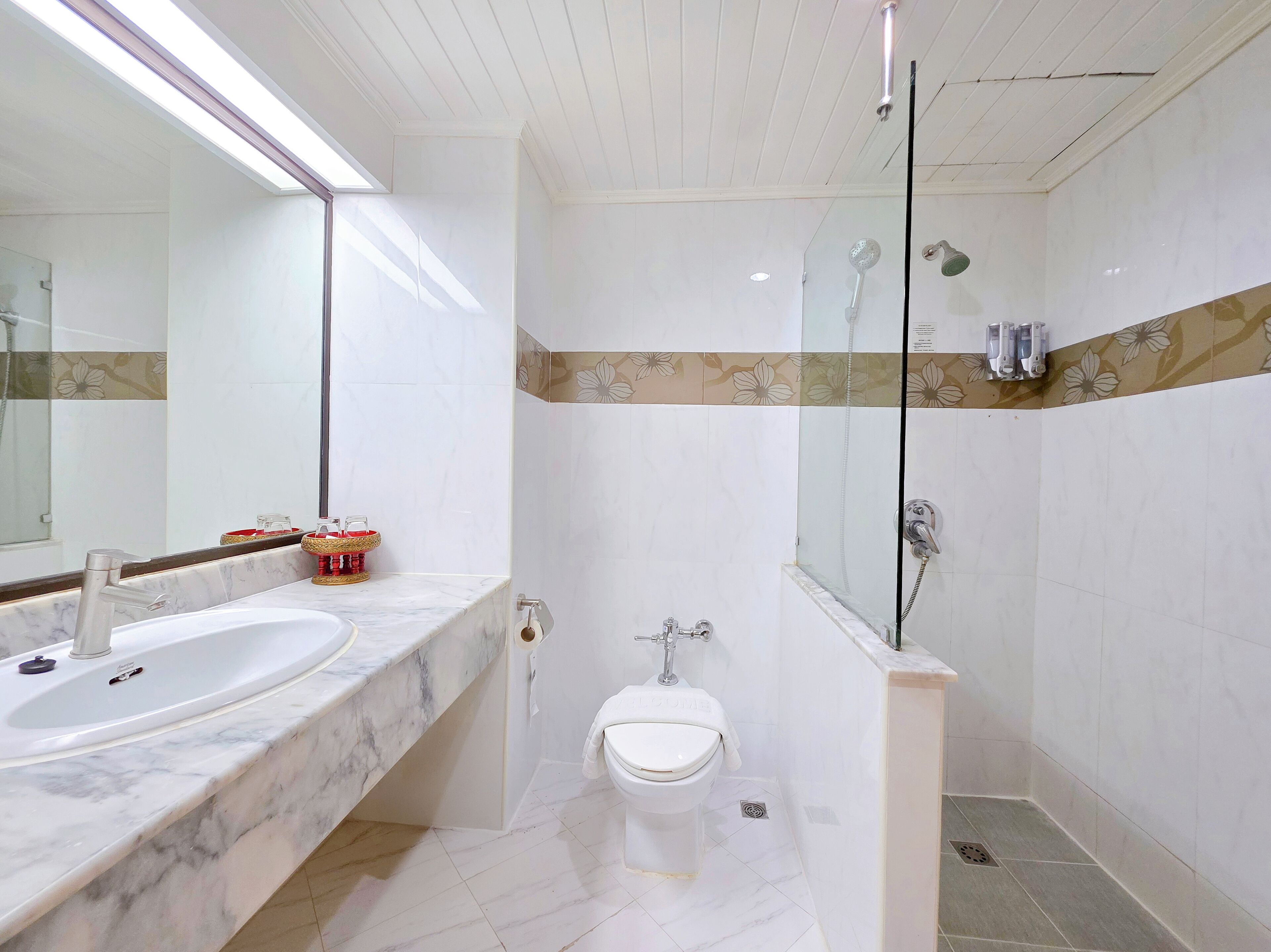 Un bagno con un lavabo in marmo, un WC e uno spazio doccia.
