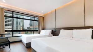 A hotel room with two beds, a desk, and a large window with a city view. - Pinnacle Lumpini Park Hotel (Bangkok)
