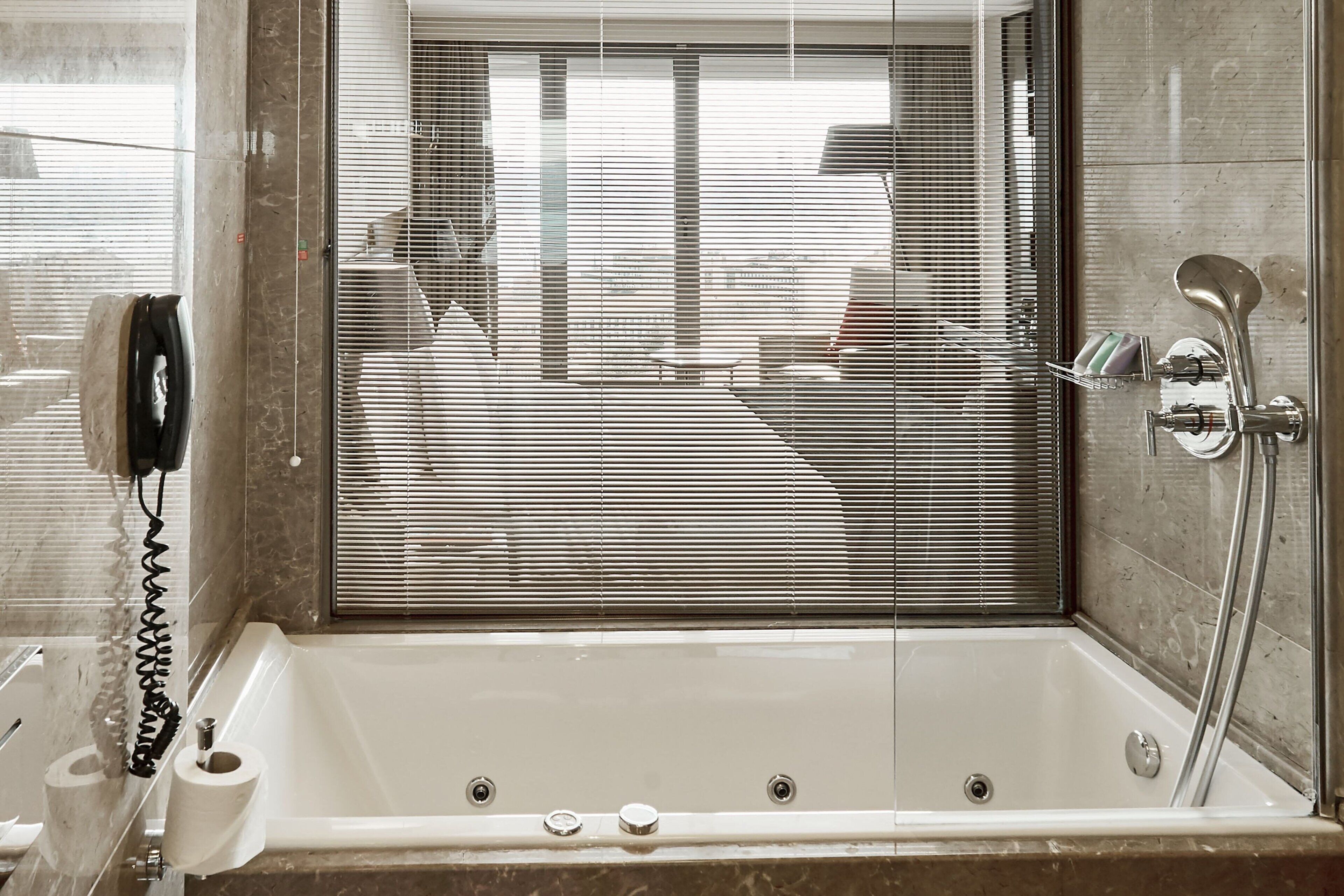 A modern bathroom with a bathtub, a toilet, and a shower.