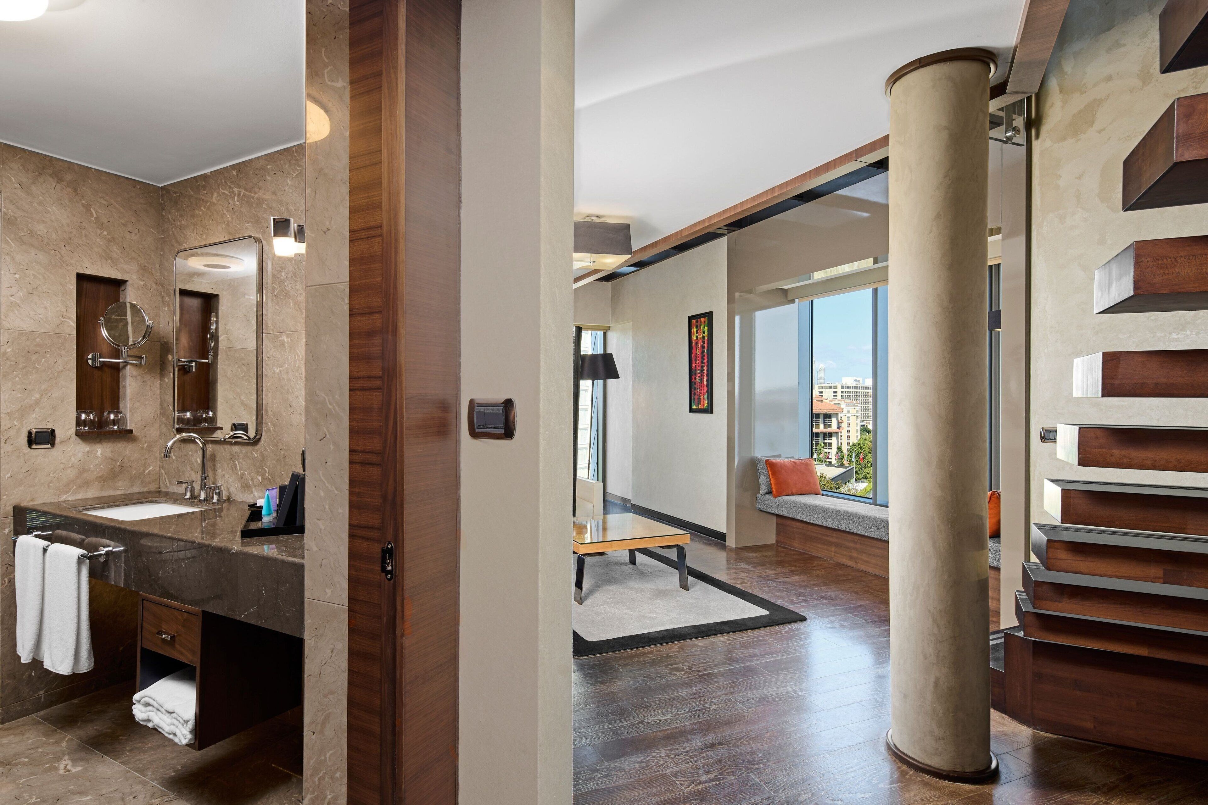 A modern bathroom with a marble sink, a large mirror, and a wooden vanity.