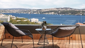 A balcony with two mesh chairs and a small table, overlooking a cityscape and a body of water. - Gezi Hotel Bosphorus, Istanbul, a Member of Design Hotels - Special Class (Istanbul)