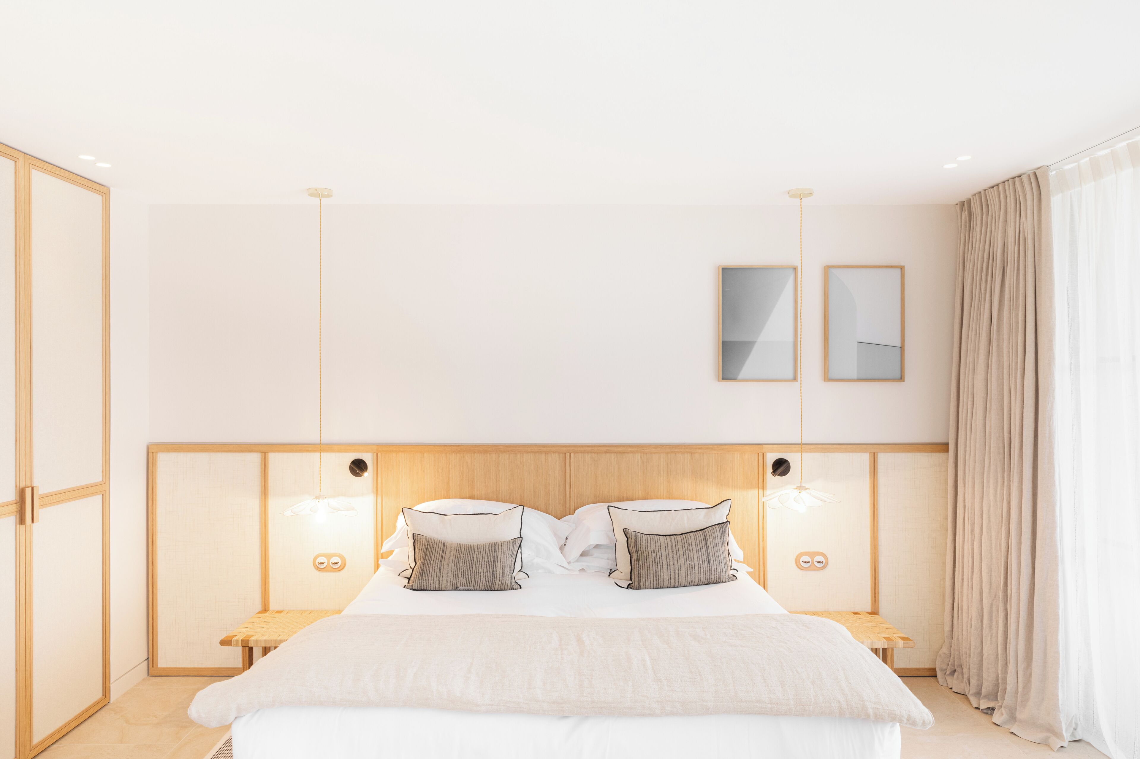 Une chambre d’hôtel moderne dotée d’un grand lit, de tables de chevet et d’une tête de lit avec éclairage intégré.