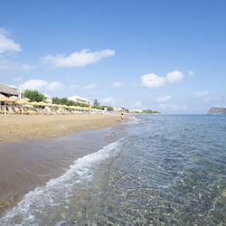 Relax on the beach with stunning sea views from this beachside hotel, featuring sun loungers and a thatched roof.