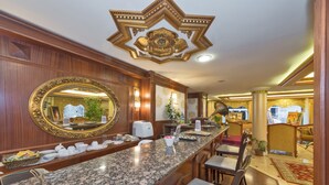 A spacious hotel lobby with a marble reception desk, a large ornate mirror, and a decorative ceiling. - Golden Horn Hotel - Special Class (Istanbul)