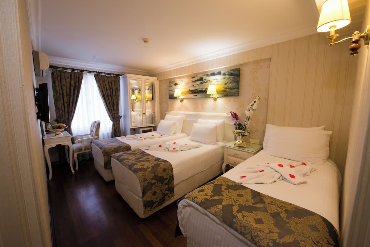 A hotel room with two beds, a desk, and a chair.