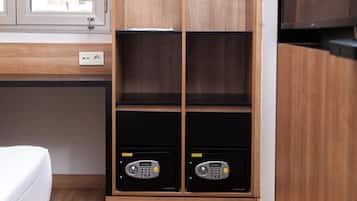 Een kamer met een houten garderobe, een bed en een bureau met een computer.