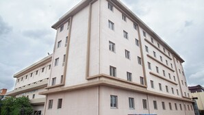 A multi-story building with a flat facade, numerous windows, and a corner entrance.