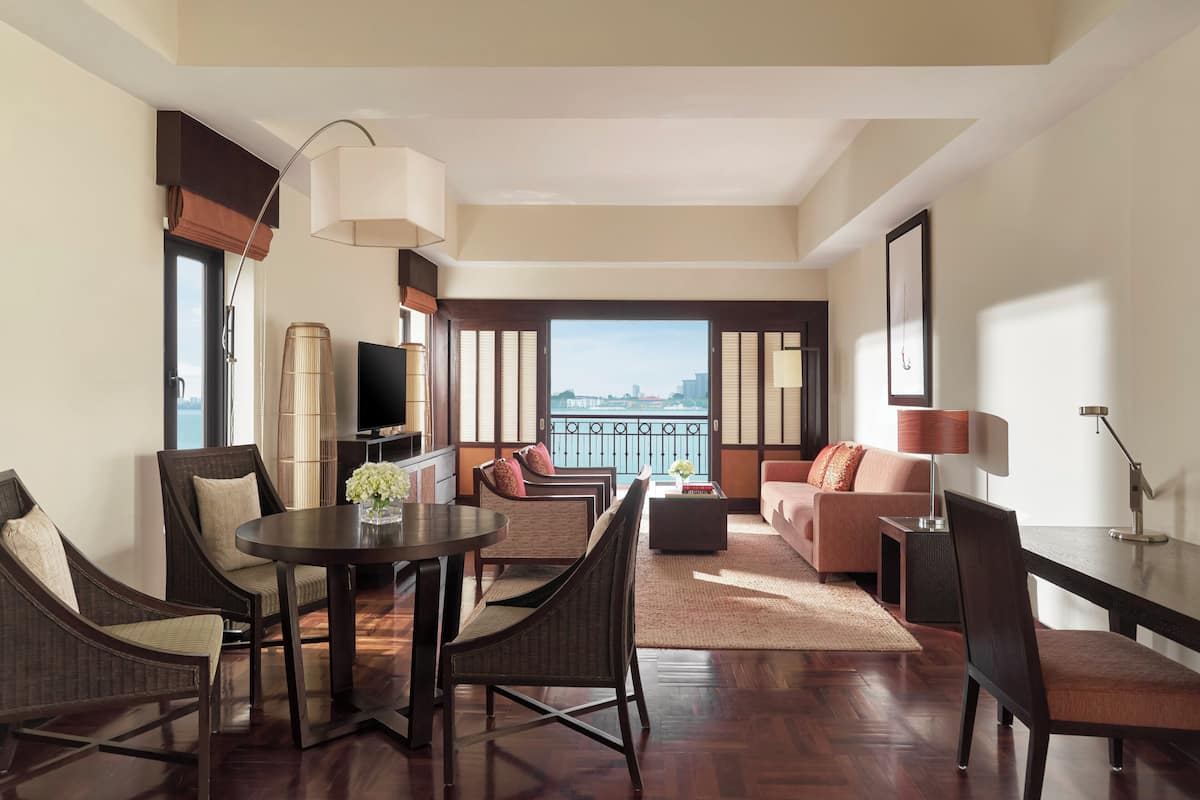 A modern living room with a dining area, a sofa set, and a large window with a city view.