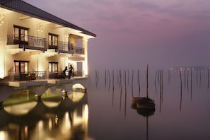 A multi-story hotel with balconies, a reflective pool, and a calm waterfront view. - InterContinental Hanoi Westlake by IHG (Hanoi)