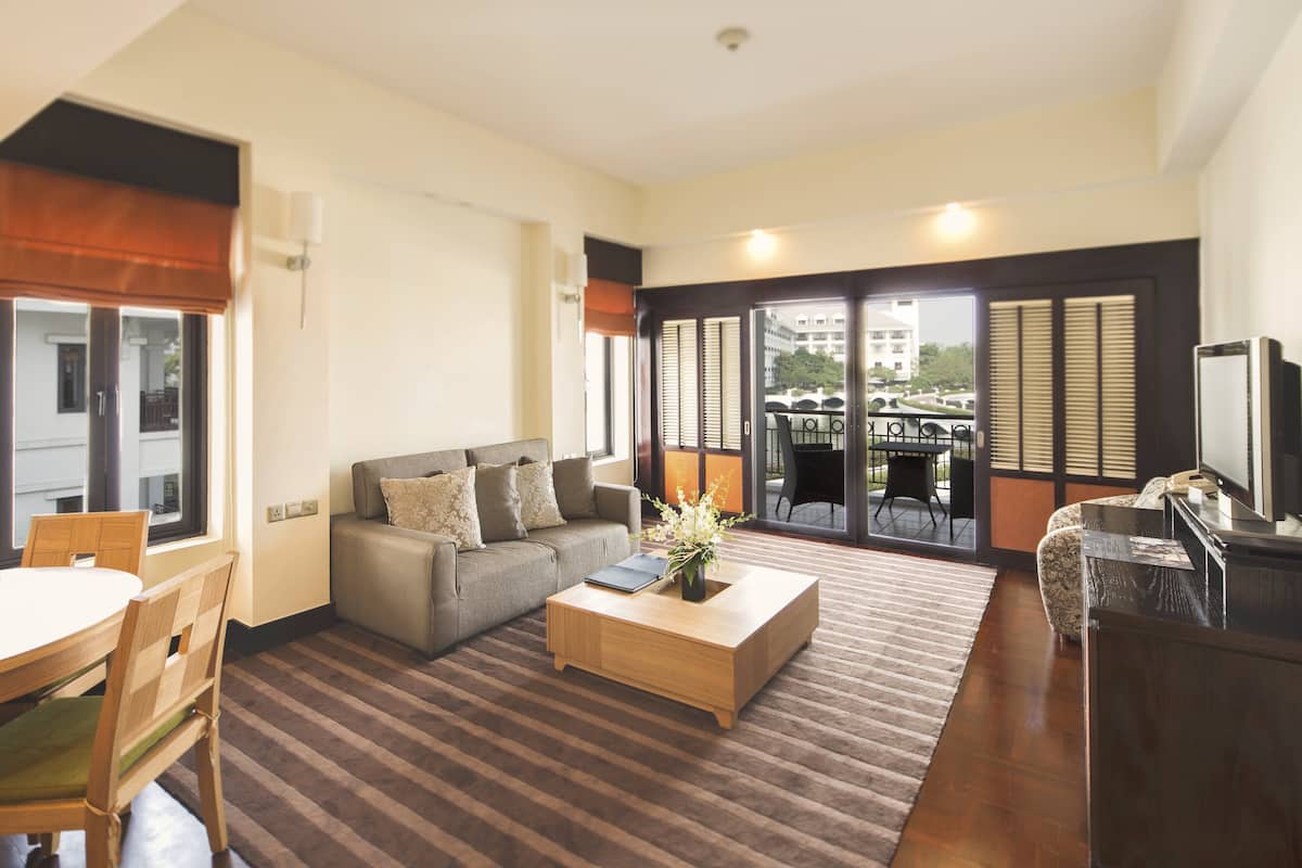 A modern living room with a sofa, coffee table, and dining area.