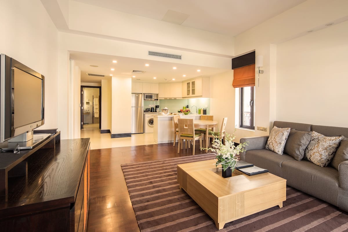 A modern living room with a flat-screen TV, a wooden coffee table, and a sofa.