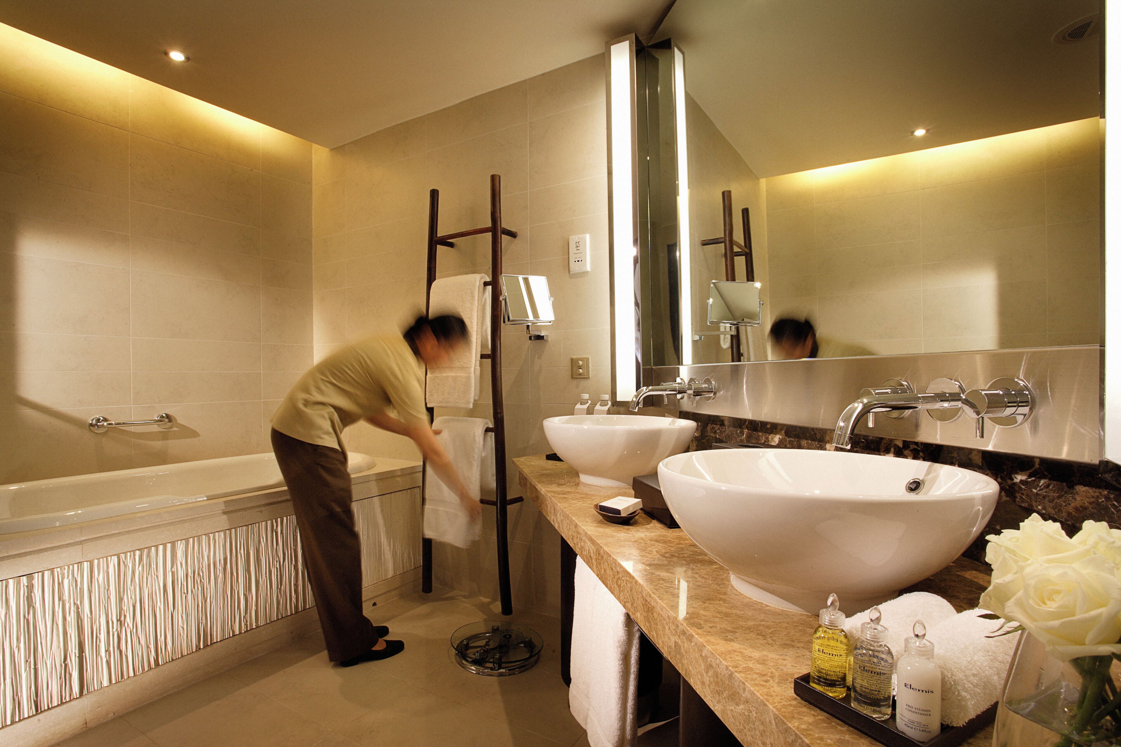 Ein modernes Badezimmer mit Badewanne, zwei Waschbecken und einem großen Spiegel.