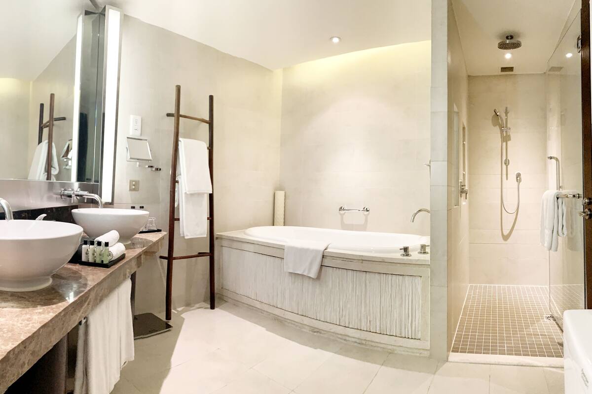 A modern bathroom with a large sink, a bathtub, and a walk-in shower.