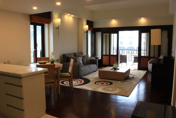 A modern living room with a sofa, coffee table, and dining area.