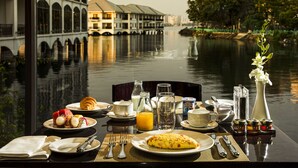 Een ontbijttafel met uitzicht op een rivier en gebouwen, waaronder een brug.