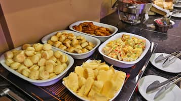 A buffet table with various dishes including potatoes, bread, and a casserole.