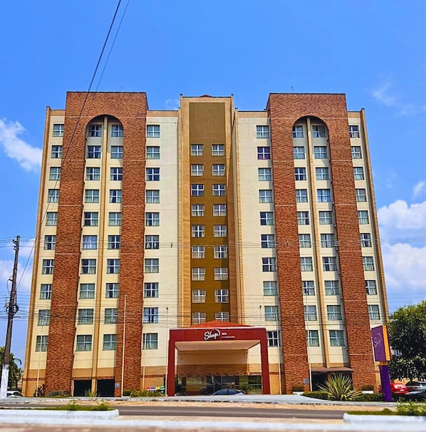 A multi-story hotel with a central atrium, a Sleep Inn sign, and a brick facade.