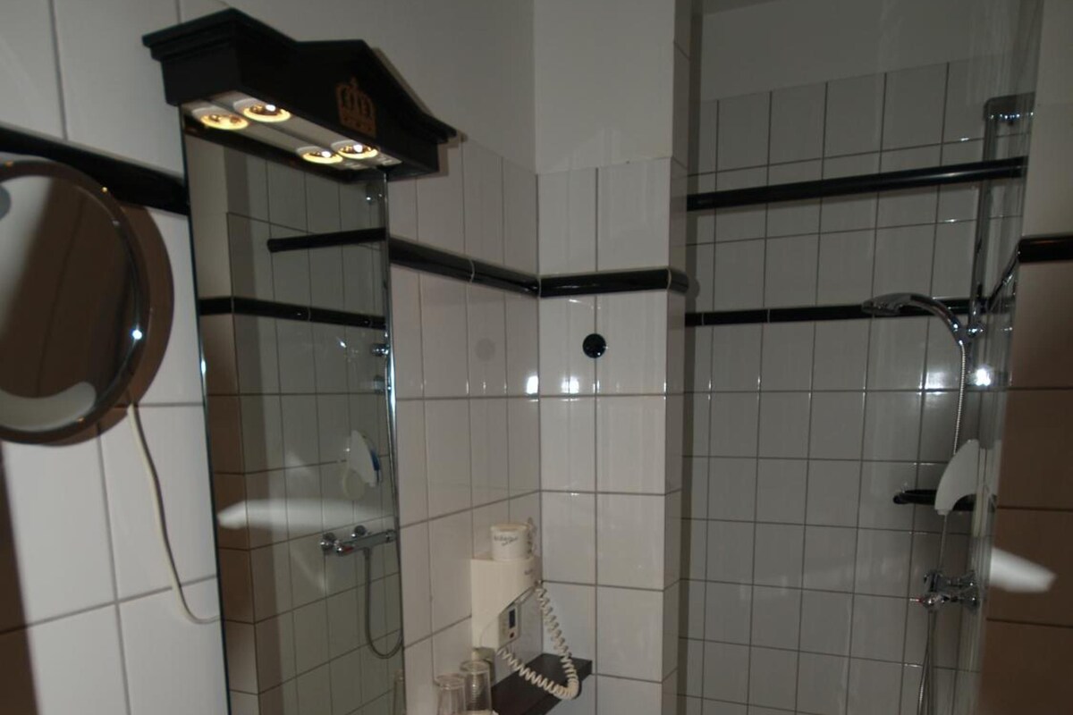 Un baño con lavamanos, espejo y ducha.