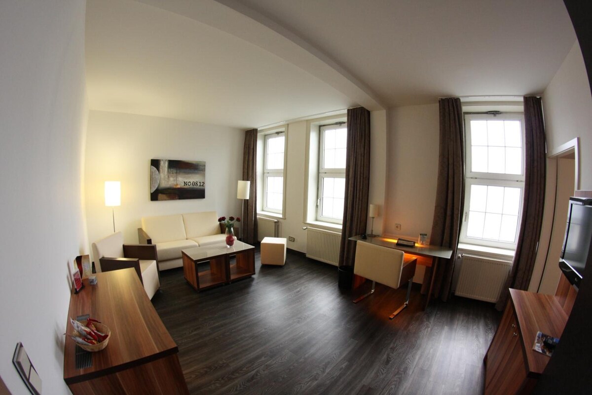 A modern living room with a sofa, coffee table, and a flat-screen TV.