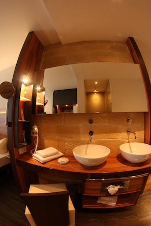 A bathroom with a wooden vanity, two sinks, and a mirror.