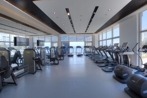 A gym with treadmills, elliptical machines, and weight equipment. - Charisma De Luxe Hotel (Kusadasi)