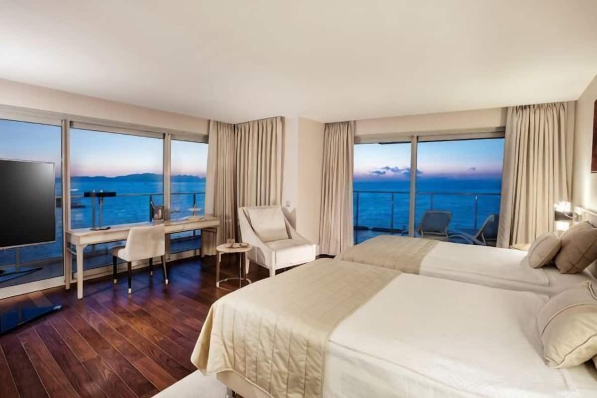 Una habitación de hotel con una cama grande, un escritorio, una silla y un televisor.
