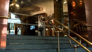 A staircase with metal handrails leading to a modern building facade with glass panels and a reflection of the interior. - Hard Days Night Hotel Liverpool (Liverpool)