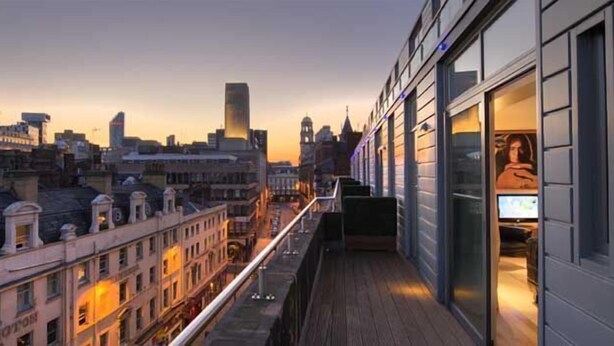 A high-rise building with a balcony overlooking a cityscape at dusk. - Hard Days Night Hotel Liverpool (Liverpool)