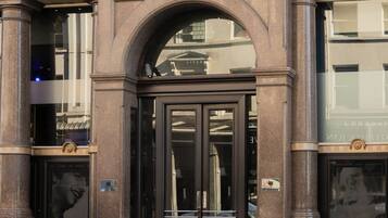 A building entrance with a black door, large windows, and a British flag.