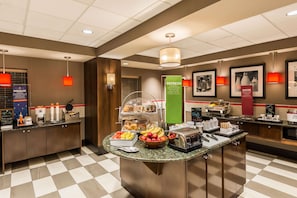A hotel breakfast area with a buffet counter, various food items, and a coffee station. - Hampton Inn & Suites Columbus Polaris (Columbus)