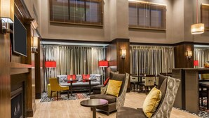 A spacious lobby with a fireplace, comfortable seating, and a television.