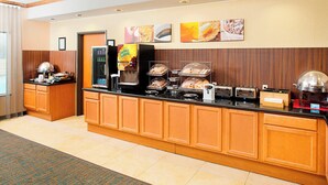 A hotel breakfast area with a buffet counter, a coffee machine, and a refrigerator. - Fairfield Inn & Suites by Marriott San Antonio Seaworld (San Antonio)