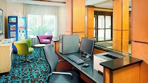 A hotel room with a desk, computer, chairs, and a large window. - Fairfield Inn & Suites by Marriott San Antonio Seaworld (San Antonio)