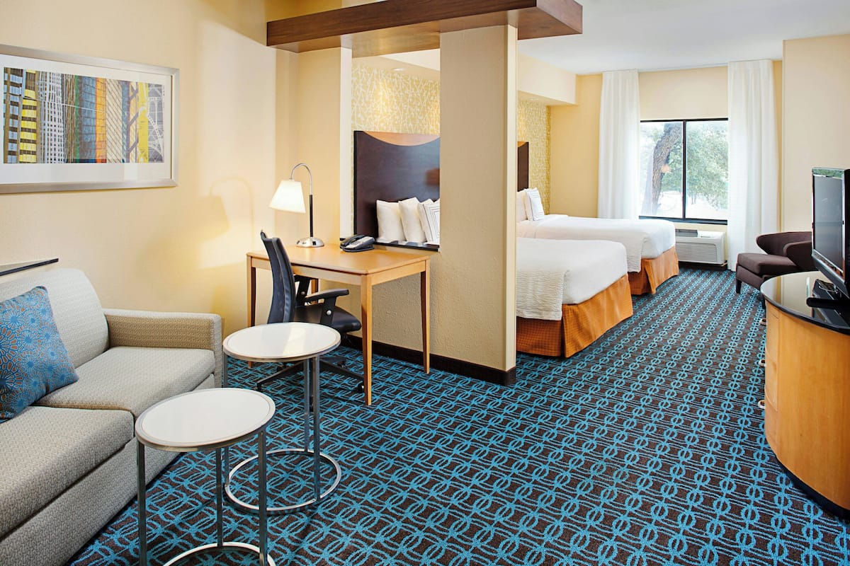 Ein Hotelzimmer mit Bett, Schreibtisch, Stuhl und Fernseher.