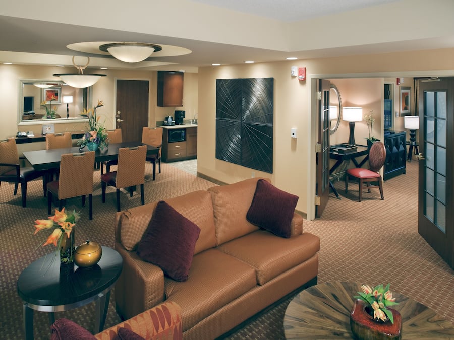 Habitación de hotel con sala de estar, comedor y kitchenette.