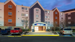 A multi-story hotel with a prominent entrance and parking area. - Candlewood Suites Chesapeake/Suffolk by IHG (Chesapeake)