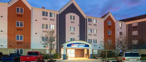 A multi-story hotel with a prominent entrance and parking area.