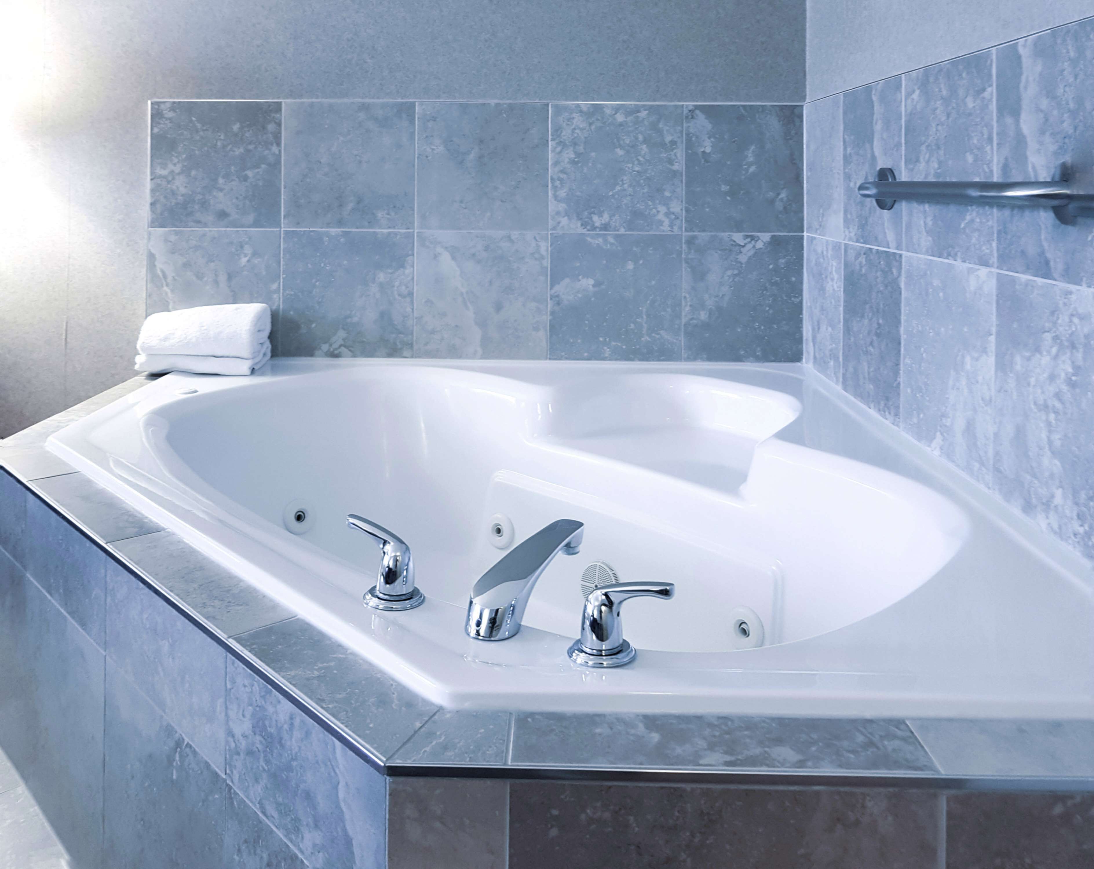 jacuzzi suite with 1 king bed | bathroom | bathtub, hair dryer, towels