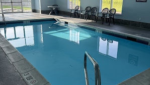 An indoor swimming pool with clear water, a diving board, and a 'No Diving Allowed' sign.