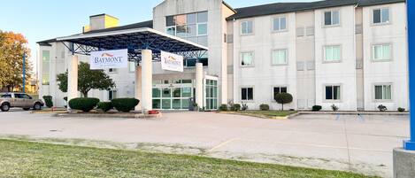 A hotel with a covered entrance, multiple windows, and a sign reading "Baymont by Wyndham".