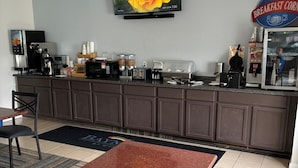 A hotel breakfast area with a coffee machine, toaster, and a Baymont sign.