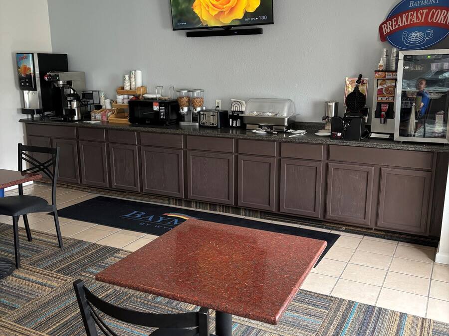 A hotel breakfast area with a coffee machine, toaster, and a Baymont sign.